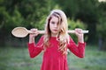 Blonde girl with big spoon in the garden Royalty Free Stock Photo