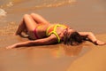 blonde girl in bikini upside view lies on back on wet sand