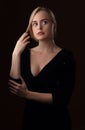 Blonde girl in a black dress with a deep neckline Royalty Free Stock Photo