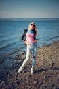 Blonde girl in black glasses and jeans posing on the beach Royalty Free Stock Photo