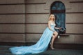 Blonde girl in a blue long dress.