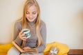 Blonde girl drinking her coffee, eat cookies and read a book Royalty Free Stock Photo