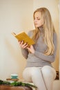 Blonde girl drinking her coffee, eat cookies and read a book Royalty Free Stock Photo