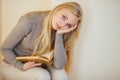 Blonde girl drinking her coffee, eat cookies and read a book Royalty Free Stock Photo