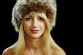 Blonde girl face closeup in fur hat