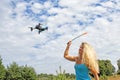 The blonde girl with a fly swatter drives away drone Royalty Free Stock Photo