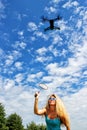 The blonde girl with a fly swatter drives away drone Royalty Free Stock Photo