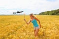 The blonde girl with a fly swatter drives away drone Royalty Free Stock Photo