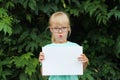 Blonde girl with glasses holding a blank sheet of paper with space for text Royalty Free Stock Photo