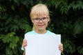 Blonde girl with glasses holding a blank sheet of paper with space for text Royalty Free Stock Photo