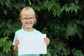 Blonde girl with glasses holding a blank sheet of paper with space for text Royalty Free Stock Photo