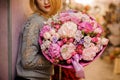 Elegant girl smiles holds a huge bouquet of different pink and purple flowers Royalty Free Stock Photo