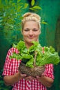 Blonde girl on a green background holding basket with lettuce