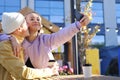 A blonde girl holds a phone and takes a selfie with her boyfriend. Young man kissing a girl Royalty Free Stock Photo