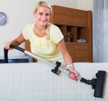 Blonde girl hoovering in living room