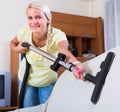 Blonde girl hoovering in living room Royalty Free Stock Photo