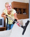 Blonde girl hoovering in living room Royalty Free Stock Photo