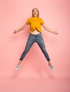 Girl jumps on pink background. Concept of freedom, energy and vitality
