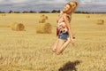 Blonde girl jumps in sloping field Royalty Free Stock Photo