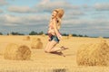 Blonde girl jumps in sloping field Royalty Free Stock Photo