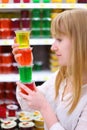Blonde girl keeps multi-colored jelly in store