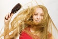 Blonde girl long blowing hair holds natural bristles brush Royalty Free Stock Photo