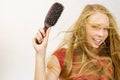 Blonde girl long blowing hair holds natural bristles brush Royalty Free Stock Photo