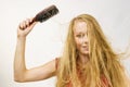 Blonde girl long blowing hair holds natural bristles brush Royalty Free Stock Photo