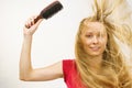 Blonde girl long blowing hair holds natural bristles brush Royalty Free Stock Photo