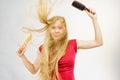 Blonde girl long blowing hair holds two brushes Royalty Free Stock Photo