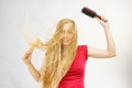 Blonde girl long blowing hair holds two brushes Royalty Free Stock Photo
