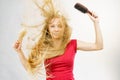Blonde girl long blowing hair holds two brushes Royalty Free Stock Photo