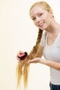 Blonde girl with long braid hair holds brush Royalty Free Stock Photo