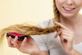 Blonde girl with long braid hair holds brush Royalty Free Stock Photo