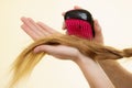 Blonde girl with long braid hair holds brush Royalty Free Stock Photo