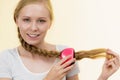 Blonde girl with long braid hair holds brush Royalty Free Stock Photo