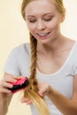 Blonde girl with long braid hair holds brush Royalty Free Stock Photo