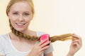 Blonde girl with long braid hair holds brush Royalty Free Stock Photo