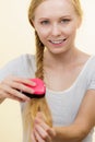 Blonde girl with long braid hair holds brush Royalty Free Stock Photo