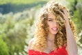 Blonde girl with long and curly wavy hair. Beautiful model with curly hairstyle. Fashion haircut. Beautiful attractive