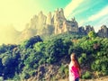 Blonde girl looks at Mountain Montserrat in Catalonia Spain and the sun shines in her face, side view. Beautiful mountain