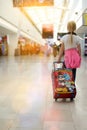 Blonde girl with luggage is going through the airport