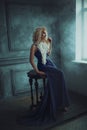 A blonde girl in a luxurious blue dress