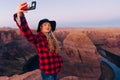 blonde girl makes selfie on Horseshoe Bend in Glen Canyon National Recreation Area in early dawn Royalty Free Stock Photo