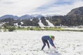 Blonde girl makes a snowman in Slovenia in the Alps