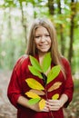 Blonde girl in a misterious forest holding a branch