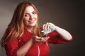 A blonde girl with an overweight plus size, in a red overallposing on a dark Studio background