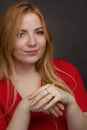 A blonde girl with an overweight plus size, a red overallposing on a dark Studio background