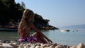 Blonde Girl Playing on Beach, Kid Throwing Pebbles in Sea Waves on Seashore, Child Plays on Coastline Shore in Summer Vacation