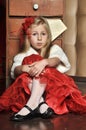 Blonde girl in a red elegant dress with a red hairpin in her hair and a white fur cape Royalty Free Stock Photo